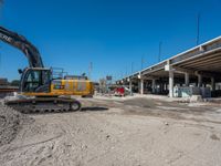 an excavating machine is on the dirt on a dirt patch in a construction area