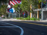 a tree lined street in front of a store with lots of flags flying in the background