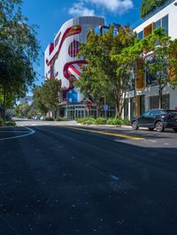 a building that is painted like an american flag, on a street lined with trees