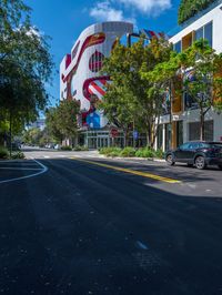 a building that is painted like an american flag, on a street lined with trees