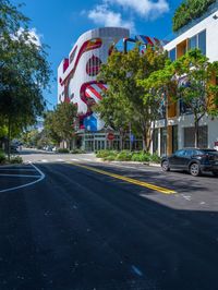 a building that is painted like an american flag, on a street lined with trees