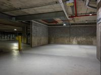 an empty parking garage with a parking meter above the fire hydrant and the light from above it