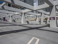 a large concrete building with several openings above it on a street in an area called a parking lot