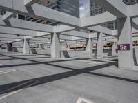 a large concrete building with several openings above it on a street in an area called a parking lot