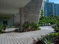 a building is in the distance and is seen from below, with an irregular - shaped concrete structure surrounded by plants