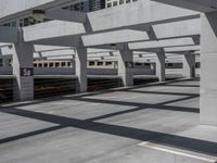 a train on track in a railway station with no trains in sight, but in a lot of concrete