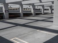 a train on track in a railway station with no trains in sight, but in a lot of concrete