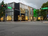 an intersection in the center of an urban area that has large windows with a lite and two red traffic lights