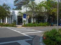 the entrance to an office is shown from the street corner, with a traffic light on