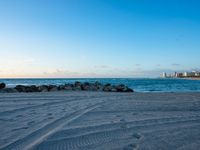 a sandy beach next to the ocean on a sunny day and with a sky background