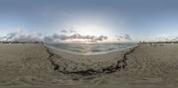 a fisheye view of the beach in the evening, from which sun is just going down