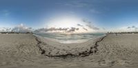 an empty beach is featured in this fish - eye picture with a hole made out of small dirt