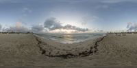 a view of an empty beach at sunset from a fish eye view camera lens that is upside down