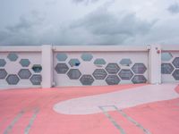 the wall is covered with red cement tiles and hexagon shaped panels that resemble windows