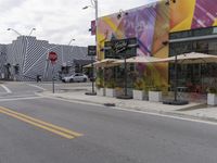 a store is painted to look like a zebra strip outside a cafe and restaurant where cars are parked