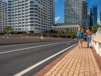 three women walking down the street together on a sidewalk outside of a hotel, two of which are white