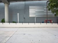 a picture of a concrete sidewalk with a fire hydrant and tree in the corner