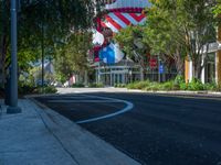 street view of red, white and blue balloon in the city center of a town