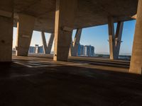 this picture is taken from underneath an overpass bridge at sunset on a clear day