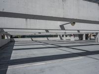 a building with multiple windows has benches in the middle of the space and shadows cast across the concrete