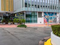 the curb is made from concrete and has plants in pots on it in front of the building