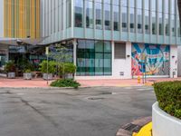 the curb is made from concrete and has plants in pots on it in front of the building