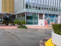 the curb is made from concrete and has plants in pots on it in front of the building