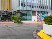 the curb is made from concrete and has plants in pots on it in front of the building