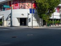 the building is painted in bright blue and white designs for cars and motorcycles with signs for street names