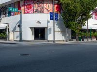 the building is painted in bright blue and white designs for cars and motorcycles with signs for street names