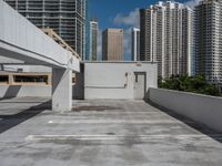 a white parking lot with no cars on top of it and some tall buildings in the background