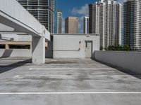 a white parking lot with no cars on top of it and some tall buildings in the background