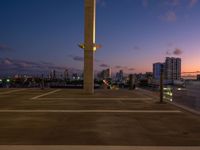 a street lamp sitting on top of a metal pole near water and buildings with tall, glass windows