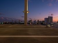 a street lamp sitting on top of a metal pole near water and buildings with tall, glass windows