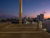 a street lamp sitting on top of a metal pole near water and buildings with tall, glass windows