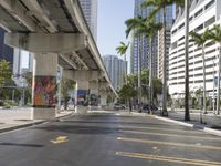 cars are driving down a city street surrounded by tall buildings and palm trees and billboards