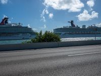 the large cruise ship is docked at the port next to a street corner with blue sky and clouds