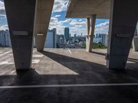 the view of a large city from a parking space with a blue sky and clouds