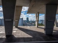 the view of a large city from a parking space with a blue sky and clouds