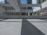 a street view of an empty parking lot with buildings in the background and shadows of the roof