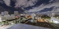 an aerial view of city buildings at night with the sky in the background and clouds