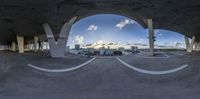 a fish eye view shows a city from underneath an overpass at dusk on a sunny day