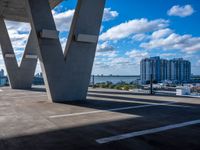 a city is next to a large building, under a bridge with the word w on it