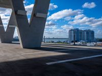 a city is next to a large building, under a bridge with the word w on it