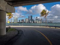 a deserted road with tall buildings in the distance by the sea side in miami, florida