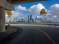 a deserted road with tall buildings in the distance by the sea side in miami, florida