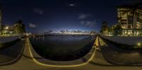 a fish eye lens shows the view from the water near a pier with buildings and a boat in the water