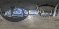 a fisheye lens is looking down on an empty city area with large concrete pillars