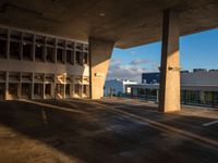 an empty parking lot next to tall buildings under a cloudy sky that is a bit dull