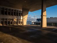 an empty parking lot next to tall buildings under a cloudy sky that is a bit dull